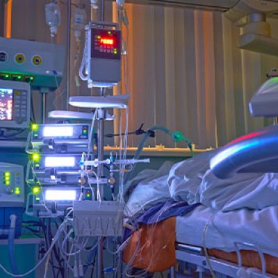 A photo of a hospital bed and medical equipment and monitors beside it. 